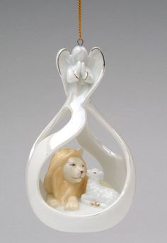 a ceramic ornament with a lion and lamb in the center hanging from a cord