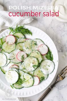 a white plate topped with cucumber salad on top of a marble countertop