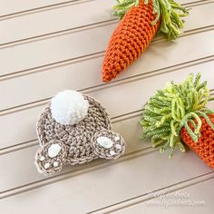 three crocheted carrots are sitting next to each other