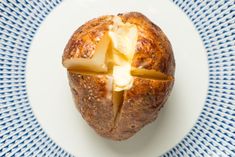 a piece of bread with cheese is on a blue and white plate