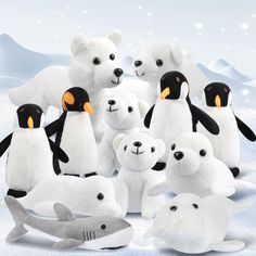 a group of stuffed animals standing next to each other in the snow with polar bears and penguins around them