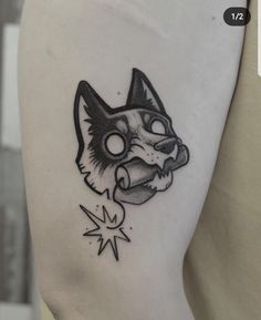 a black and white cat tattoo on the left side of the right arm, with stars around it