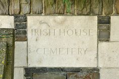 a stone sign on the side of a building that says, irish house and cemetery