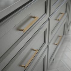 a close up of a dresser with brass handles