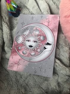 a card with an image of the sun and moon on it sitting on a blanket