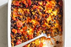 a casserole dish with black beans, tomatoes and other toppings in it