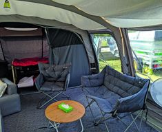 the inside of a camper with chairs and couches in front of it's windows