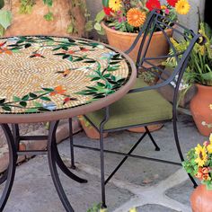 a mosaic table and chairs with potted flowers