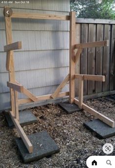 a wooden bench sitting in the middle of a yard next to a fence and building