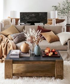 a living room filled with lots of furniture next to a white carpeted floor covered in pillows