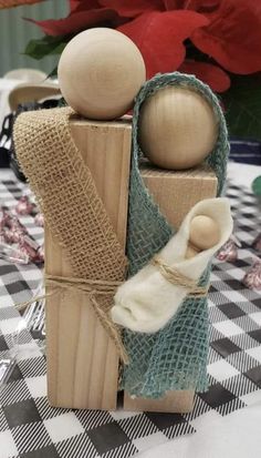 a couple of wooden dolls sitting on top of a table covered in burlocks