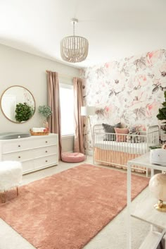 a baby's room with floral wallpaper and pink rugs on the floor