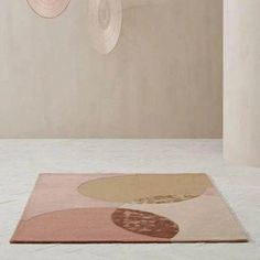 an area rug with circles hanging from the ceiling in front of a white wall and floor