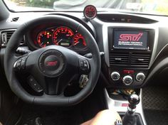 the interior of a car with steering wheel and gauges