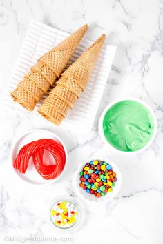 ice cream cones, candy and sprinkles on a marble countertop top