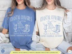 two women wearing coastal t - shirts sitting next to each other