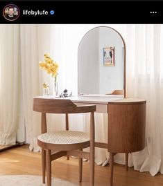 a wooden vanity table with a mirror and stool