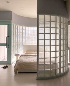 a bedroom with a circular bed and glass walls