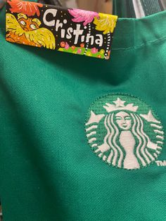 a green starbucks shirt with the name cristina on it