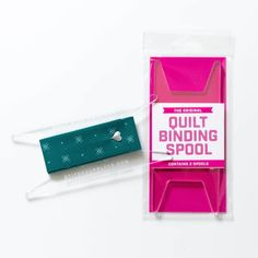 the packaging is pink and green, with a white string attached to it that says quilt binding spool