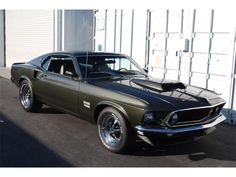 an old muscle car parked in front of a building