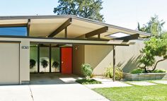 a house with a red door and green grass