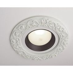 a white ceiling light with an ornate design on the front and center piece in black