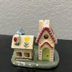 two ceramic houses sitting on top of a table