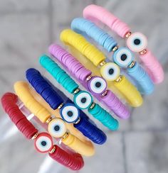 a bunch of bracelets that have different colored eyes on them