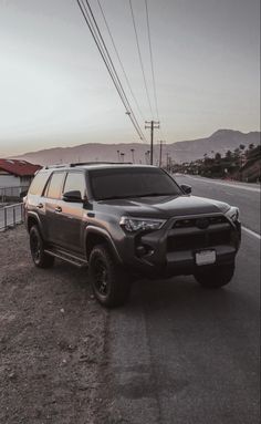 a black truck is parked on the side of the road