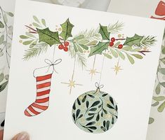 a hand holding up a card with christmas decorations on it