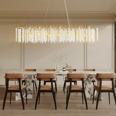 a dining room with a chandelier hanging from the ceiling