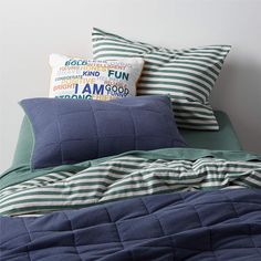 a bed with blue and green pillows on top of it