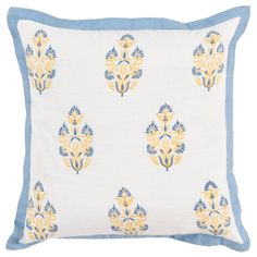 a blue and yellow pillow with an ornate design on the front, sitting on a white surface