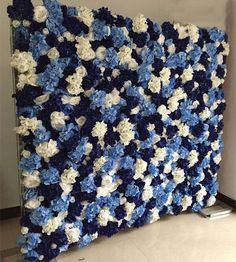 a blue and white crocheted blanket hanging on a wall