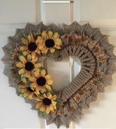 a wreath with sunflowers is hanging on the front door and it's made out of burlocks