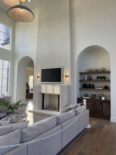 a large living room with white walls and wood floors