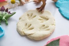 a child's hand reaching for a doughnut on a table with other toys