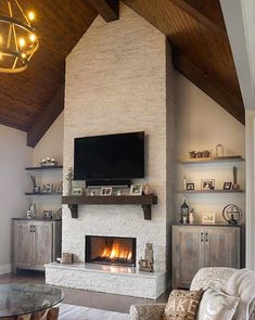 a living room filled with furniture and a flat screen tv mounted on the wall above a fire place