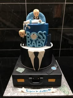 a cake that is sitting on top of a suitcase in the shape of a boss's baby