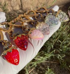 a person is holding several heart shaped key chains