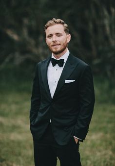 a man in a tuxedo poses for a photo