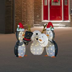 two snowmen are standing next to each other in front of a building with lights