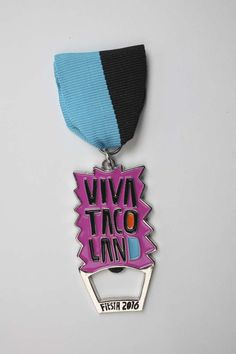 a medal with a ribbon around it that says viva taco lan on the front