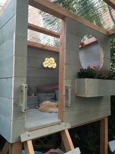 a dog house built into the side of a wooden structure with plants growing out of it