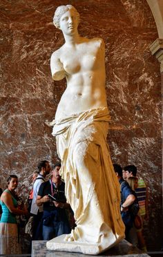 a group of people standing around a statue