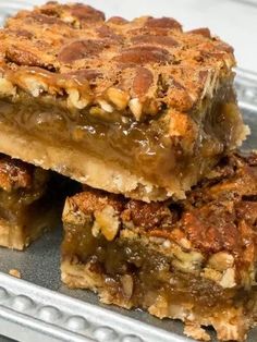 three pieces of pecan bar sitting on top of a metal tray