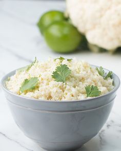 a bowl filled with rice and cilantro on top of a marble countertop