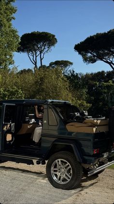 a black jeep parked in front of some trees