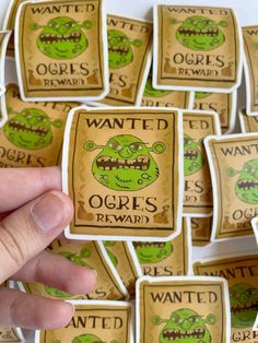 someone is holding up some stickers with the words wanted in green and brown on them